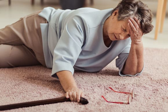 older woman fallen on floor with cane